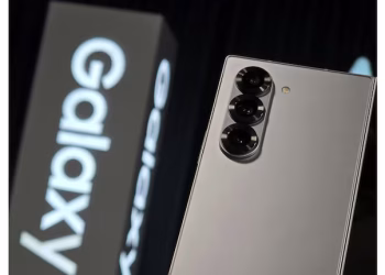 A Samsung Galaxy S26 series smartphone displaying an emergency satellite messaging interface with a "sending" status icon and clear sky background.