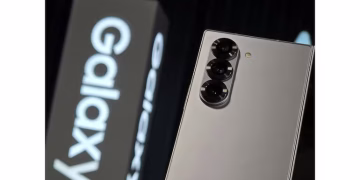 A Samsung Galaxy S26 series smartphone displaying an emergency satellite messaging interface with a "sending" status icon and clear sky background.